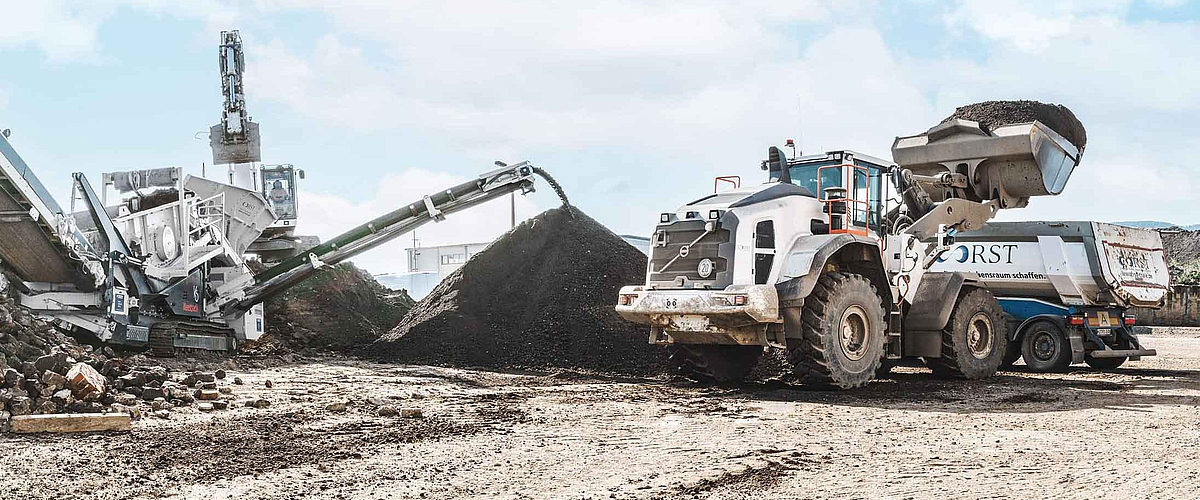 Baugeräte der RST Thale auf dem Firmengelände Thale Nord weißer Radlader, Bagger, Lkw und weiße Siebanlage des Unternehmens RST Thale neben Schutthaufen